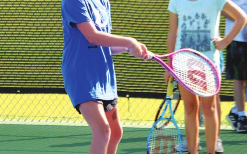 Aleighssa Donker prepares to hit a backhand shot back to head coach Kenneth Peiser at tennis camp. HUNTER KING | DISPATCH RECORD
