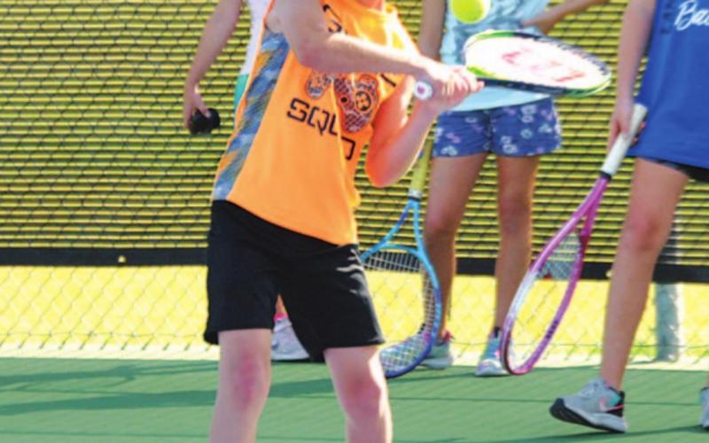 Kurt Hannabass begins to swing on his backhand during the final day of June’s tennis camp last Thursday. HUNTER KING | DISPATCH RECORD