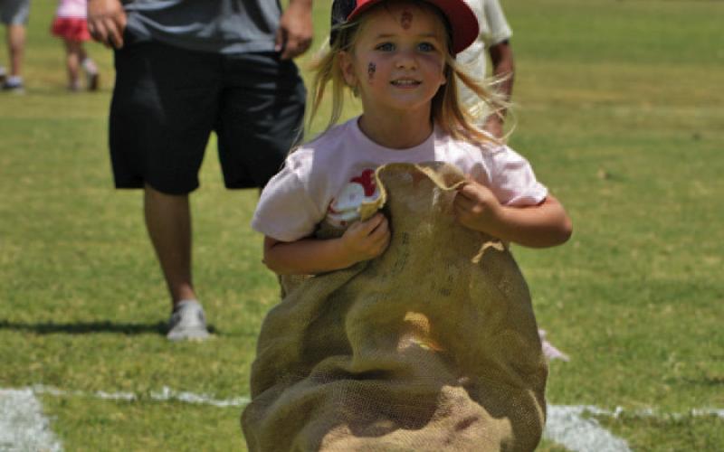 Remi Combs hops her way to the finish line during Kids’ Day activities. ERICK MITCHELL | DISPATCH RECORD