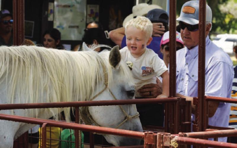 Robby Vann assists his grandson, Jace Perkins, get up close and personal with a new friend. ERICK MITCHELL | DISPATCH RECORD