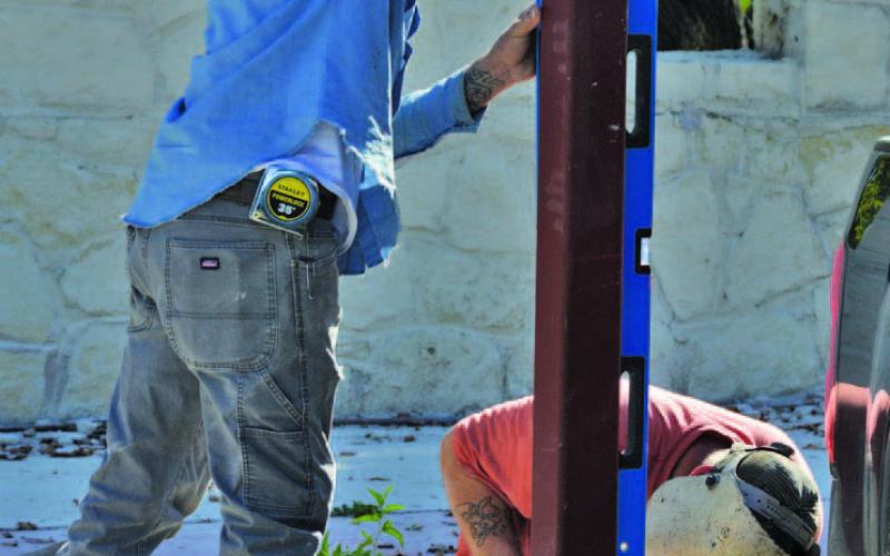 Irvin Steel Construction’s Jon Sanders holds a steel beam while Joe Cooker welds the beam into place during restoration on the historic East Fourth Street church. Lampasas Heritage Foundation is leading the project to restore the roughly 100-yearold church after its west wall collapsed about six years ago. FILE PHOTO