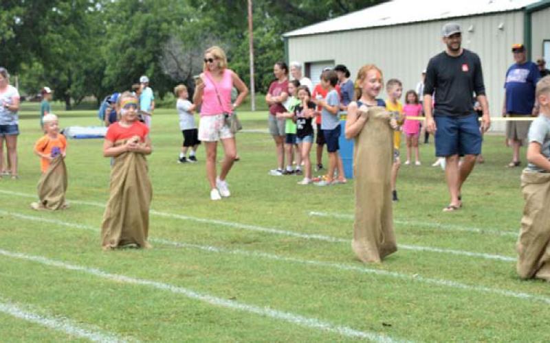 Sack race participants hop to the finish line during Kids’ Day Activities at Gavin Garrett Soccer Field. FILE PHOTO