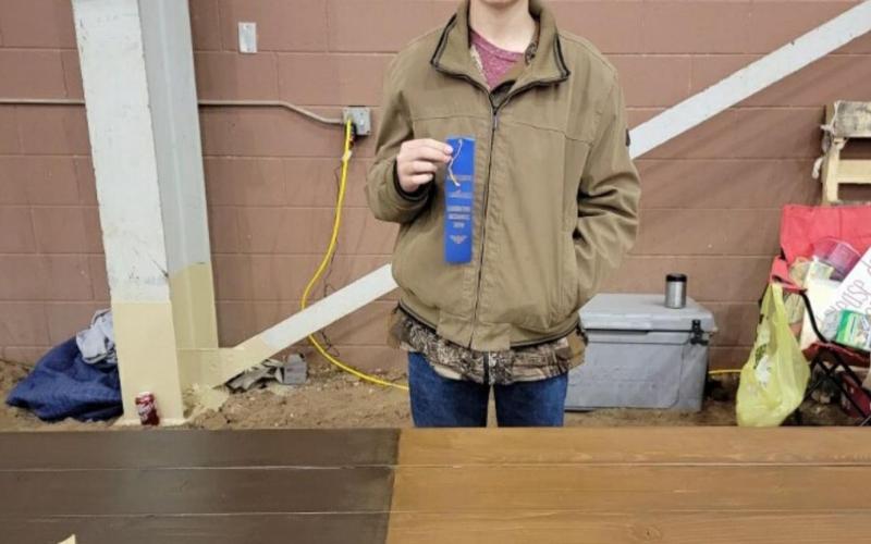 Jonathan Harris displays the blue ribbon he earned for his Texas picnic table at the San Angelo Ag Mechanics competition. He also took home a red ribbon for a belt buckle he crafted. COURTESY PHOTO