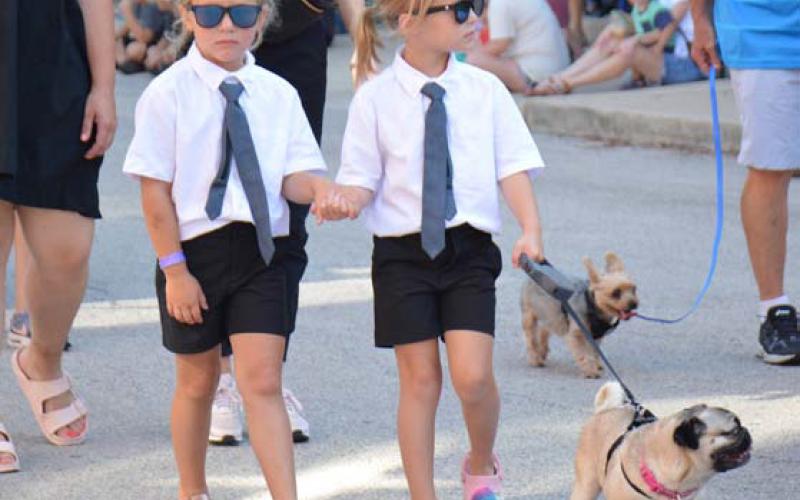 ALEXANDRIA RANDOLPH | DISPATCH RECORD Sloan Dewald and Cooper Tidwell dressed up as the Men in Black with pug, Loretta, for Friday’s Pet Parade.