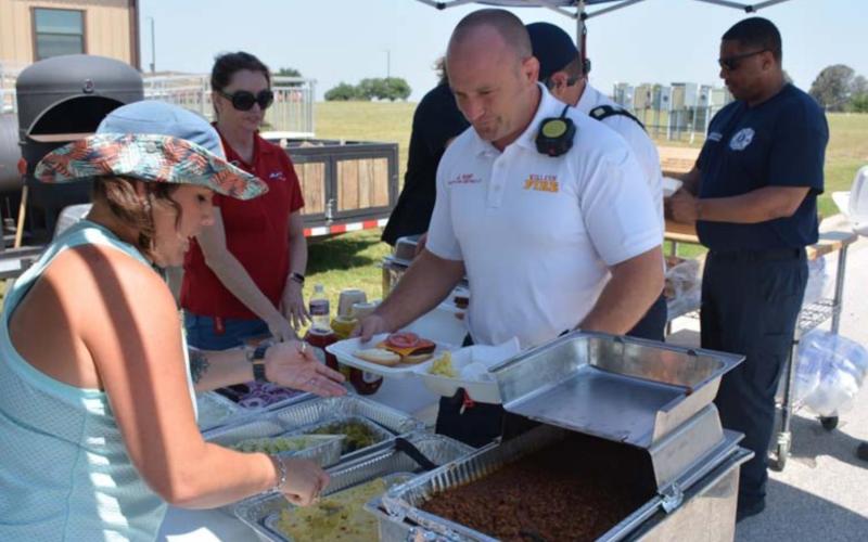 Air Evac member Tawyla Bomar serves Killeen Fire Department Battalion Chief Justin Kemp at last week’s first responder cookout during National EMS Week. MASON HINES | DISPATCH RECORD
