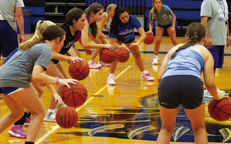 Campers focus on the power dribble in the high school gym. HUNTER KING | DISPATCH RECORD