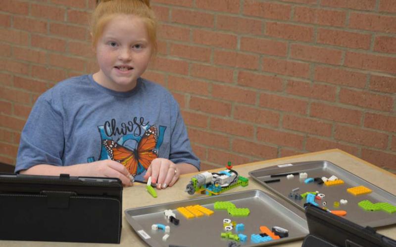 MONIQUE BRAND | DISPATCH RECORD Lauren Martin builds her robot project. Each student has use of a computer tablet with instructions and a controller. The library’s robotics initiative has grown since the program started in 2017. Sessions are offered for homeschool and public school students.