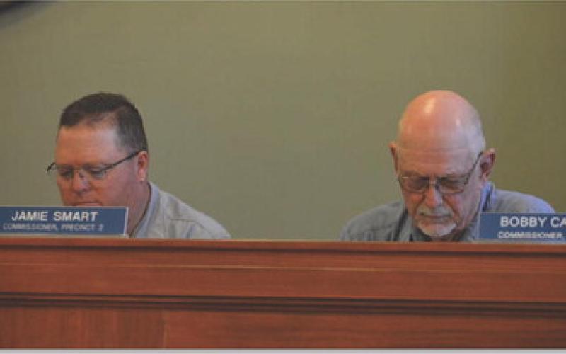 County Commissioners Jamie Smart, left, and Bobby Carroll review details of an interlocal agreement to continue transportation services with the Hill Country Transit District. Although the county will not contribute funding, the agreement is needed to retain state and federal funds. ERICK MITCHELL | DISPATCH RECORD