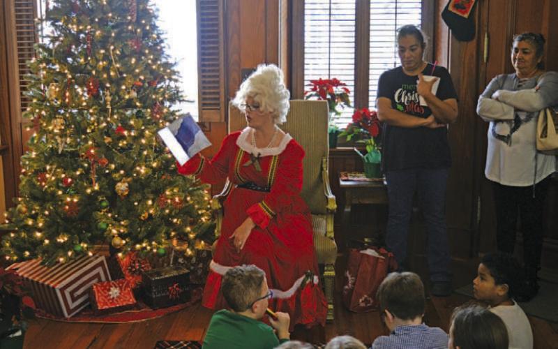 Mrs. Claus reads stories to children during her visit to Lampasas on Saturday at the Manual Hardware building. ERICK MITCHELL | DISPATCH RECORD