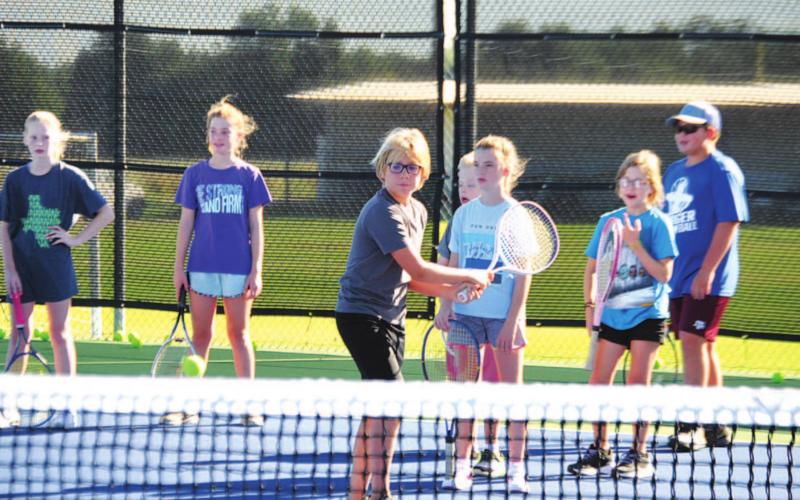 Jack Allison works on his backhand during tennis camp Tuesday morning. HUNTER KING | DISPATCH RECORD