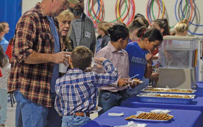 Students involved in the Hanna Springs Elementary School student leadership group “World Changers” assist veterans with their coffee, tea and cookies during Thursday’s Veterans Day reception. erick mitchellE | DISPATCH RECORD