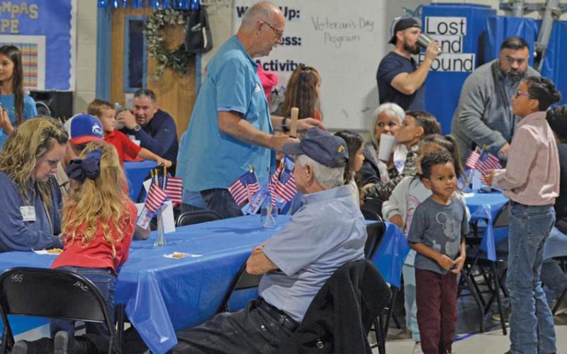 Students and their veteran family members look for a place to sit during Thursday’s reception at Hanna Springs Elementary School. erick mitchell | DISPATCH RECORD