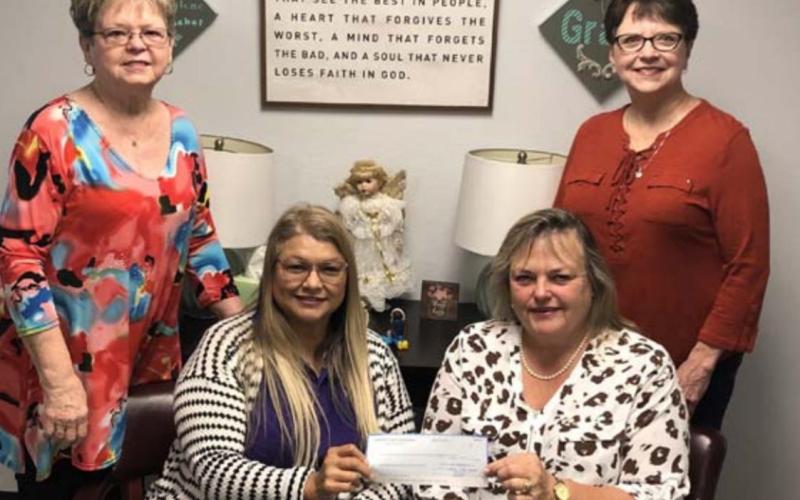 Lampasas County Farm Bureau directors Donnis Self, left, and Patsy Stoneham, at far right, present a donation to New Beginning of Restoration and Hope Pregnancy Center -- represented by Executive Director JoAnn Mensch, second from left, and Jeanice Robinson. COURTESY PHOTO