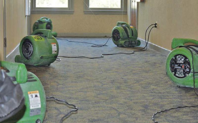 ServPro representatives assisted with water removal in the county annex offices and set up fans to help dry the areas flooded over the weekend by a malfunctioning drinking fountain. erick mitchell | dispatch record