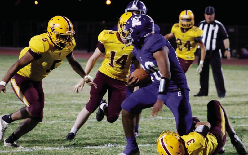 Jordan Livesay (3) wrangles an Eden ball carrier, while Elijah Gonzales (5) and Colton Whitehead (14) pursue. MASON HINES | DISPATCH RECORD