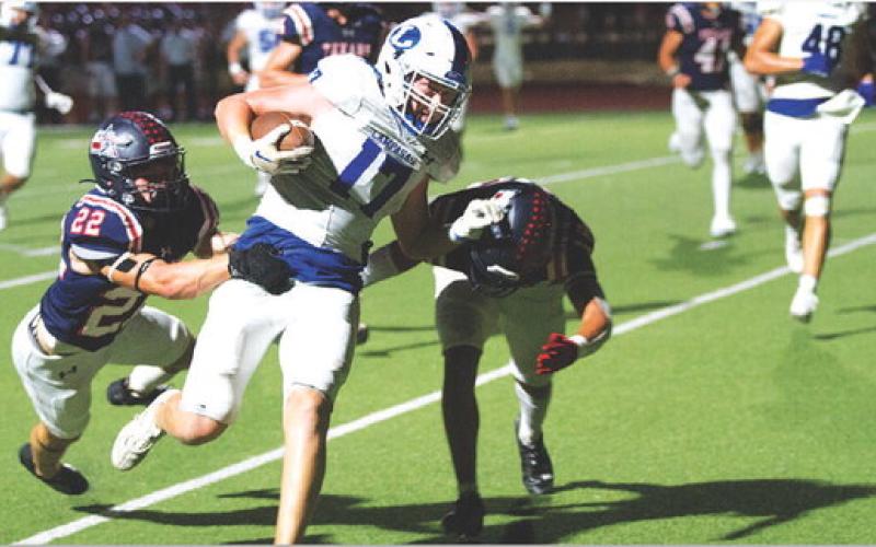 Preston Isom fights through two Wimberley tacklers on his way to the end zone last Friday night. HUNTER KING | DISPATCH RECORD