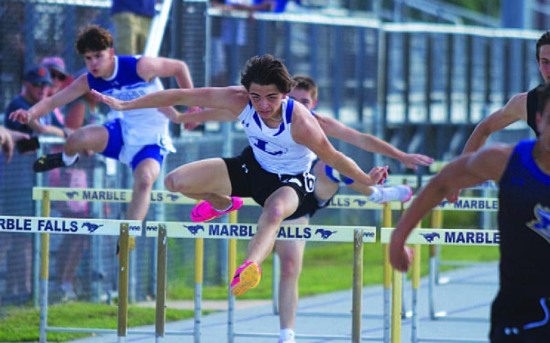 Asa White leaps over a hurdle during the 110-meter race. He qualified for area in both hurdles races. HUNTER KING | DISPATCH RECORD