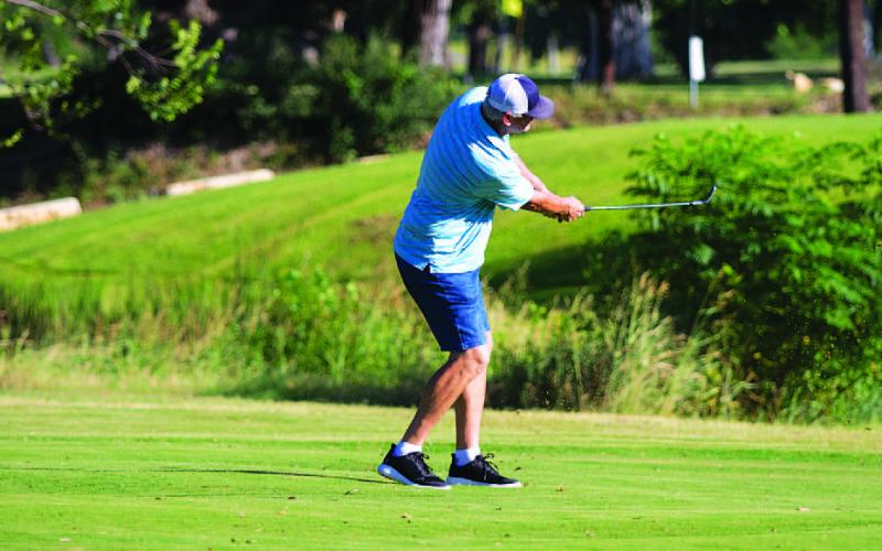 Ron Acker hits a short wedge shot on the fifth hole during Thursday’s tournament. HUNTER KING | DISPATCH RECORD