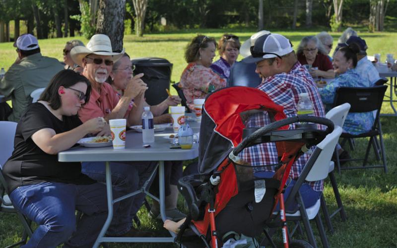 Precinct 1 Commissioner Bobby Carroll takes a look at the camera while enjoying his fish dinner with county road hand Zach Griffin, at right, and his wife Morgan, left. ERICK MITCHELL | DISPATCH RECORD