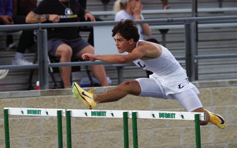 HUNTER KING | DISPATCH RECORD Colter Sellers leaps over a hurdle at the district track meet in Burnet.