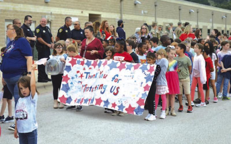 Taylor Creek Elementary School students parade a banner that reads “Thank you for protecting us” before Wednesday’s Sept. 11 remembrance ceremony begins. ERICK MITCHELL | DISPATCH RECORD