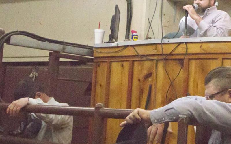 Lampasas Cattle Auction owner Andy Baumeister, at back right, prays before starting a Wednesday sale in March 2020, when COVID shutdowns closed many businesses. He has had ownership of the auction business since 2019. FILE PHOTO