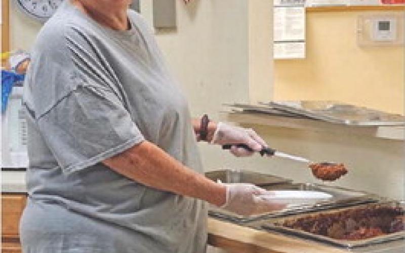Theresa Weichert serves barbecue beef to feed those who gather for a meal and socialization at the Lampasas Senior Center. Joycesarah McCabe | Dispatch Record
