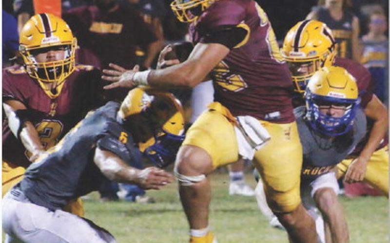 Lukas Smailus-Cruz rumbles through two Rochelle defenders. Smailus-Cruz had 357 yards and five touchdowns in Friday’s contest. MASON HINES | DISPATCH RECORD