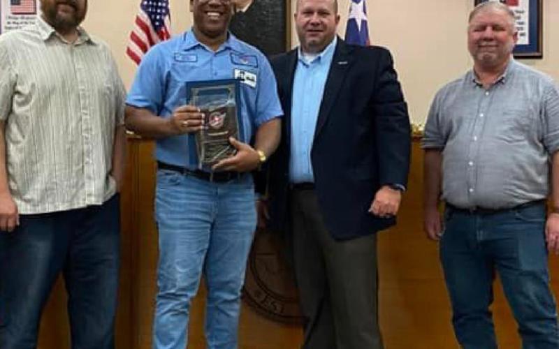 Kempner Iron and Metal manager Walter Gibson, center, holds his Impression Award. He is pictured with city officials, from left, Councilman Dan Long, Mayor John Wilkerson and Councilman Tom Combs. CITY OF KEMPNER FACEBOOK PAGE
