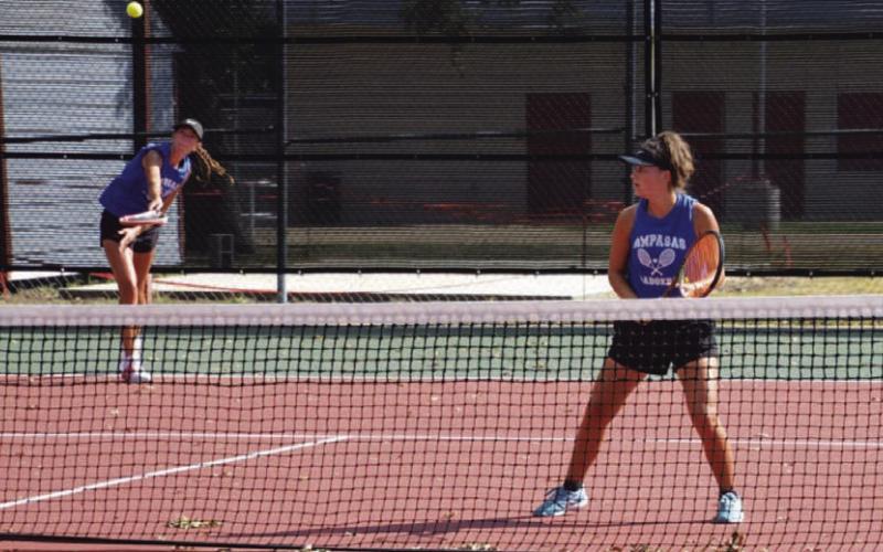 COURTESY PHOTO | KENNETH PEISER Chesley Breuer serves as Caroline White watches during a doubles match last week.