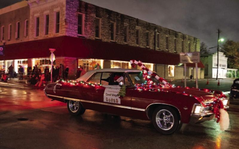 Parade Grand Marshal Carol Wright waves to the crowd gathered to watch this year’s Christmas parade. JOYCESARAH MCCABE | DISPATCH RECORD