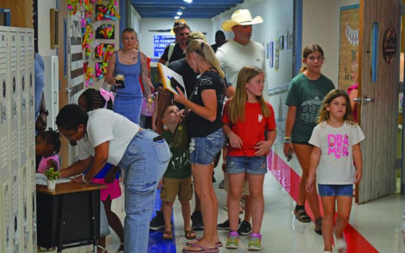 Parents sign students into their new class as others roam the hallway looking for the right classrooms during Tuesday’s Meet the Teacher night at Hanna Springs Elementary School. ERICK MITCHELL | DISPATCH RECORD