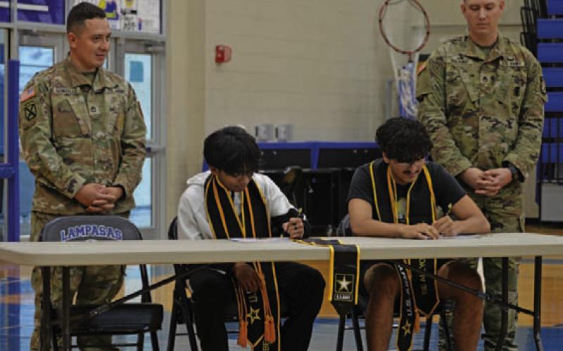 Students Jeny Obeda, left, and Xavier Weber made their place in the U.S. Army official during Monday’s signing ceremony. ERICK MITCHELL | DISPATCH RECORD