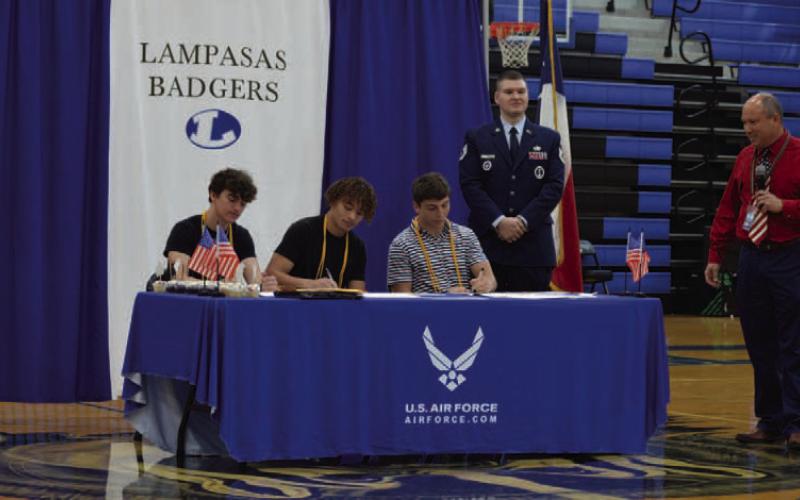 Lampasas High School students, left to right, Matthew Meeks, Charles Jackson and Cole Warren put pen to paper during Monday’s Armed Forces signing ceremony as they commit to service in the Air Force. ERICK MITCHELL | DISPATCH RECORD