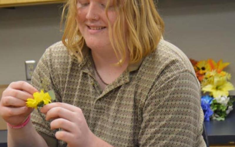 Lampasas High School junior Reighn Webb collects flowers for a project in his floral class Friday afternoon. MONIQUE BRAND | DISPATCH RECORD