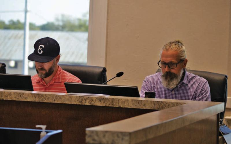 Economic Development Corp. board members Fin Erwin, left, and Michael Gill read through materials in their meeting packets. Wednesday’s session was the EDC’s first after the appointment of a new board. ERICK MITCHELL | DISPATCH RECORD