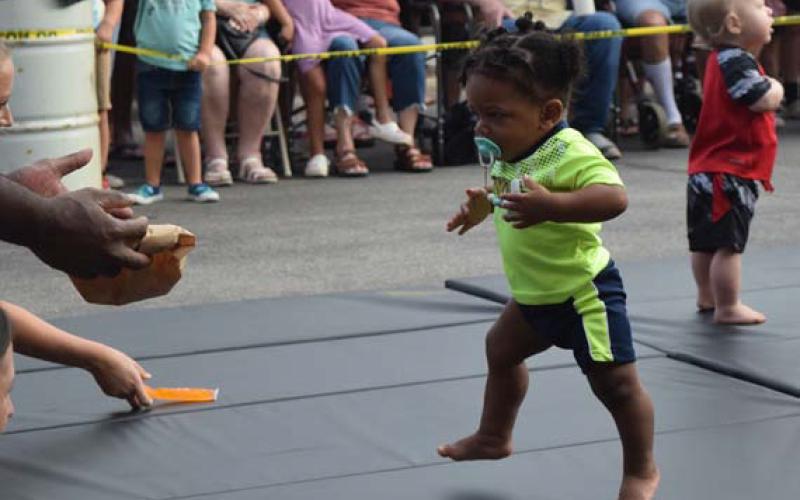 Kamden Roberts of Lampasas hurtles toward the open arms of his grand-uncle, Scott Roberts, not pictured, during heat 1 of the 10- to 12-month age group. Kamden had a quick start and finished his race in first place. ALEXANDRIA RANDOLPH | DISPATCH RECORD