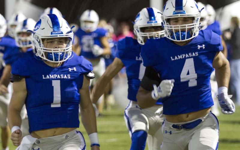 Luke Smith, left, and Aden Rascoe take the field out of the tunnel before the game against Burnet last week. HUNTER KING | DISPATCH RECORD