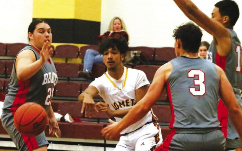 Leonel Caso threads the needle with a pass between three defenders in Lometa’s 71-37 win. MASON HINES | DISPATCH RECORD