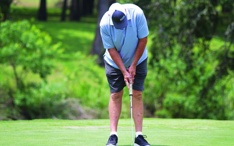 HUNTER KING | DISPATCH RECORD Ron Acker hits a short par putt during day two of the tournament on Sunday.
