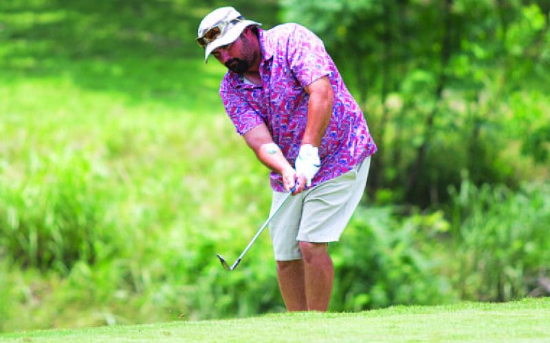 Gerry Spore chips onto the green in the A.C. January Memorial tournament. HUNTER KING | DISPATCH RECORD