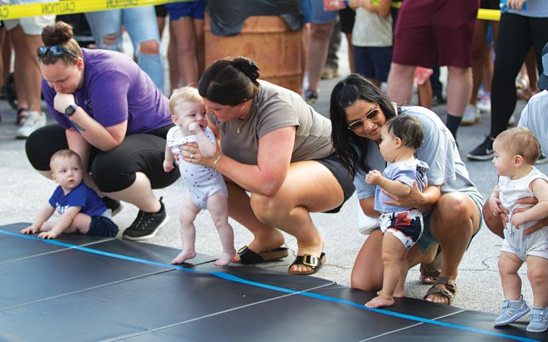 Mothers provide words of encouragement to their little ones before they take on the grueling Diaper Derby event. hunter king | dispatch record
