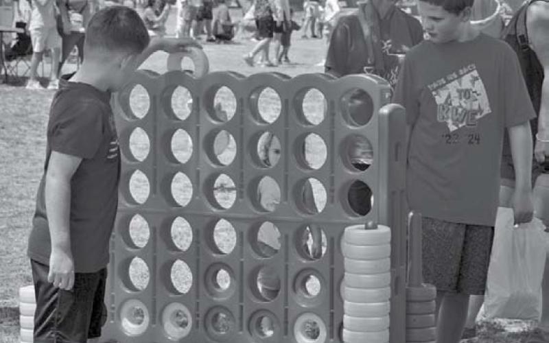 Children play a game of connect-four during Spring Ho Kids’ Day activities. Erick Mitchell | Dispatch Record