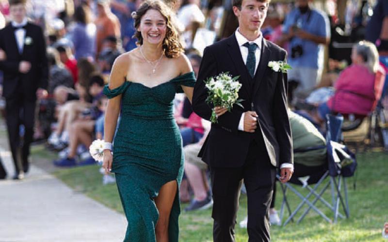 From left, Caroline White and Tyler Ecker walk to the W.M. Brook Park suspension bridge during Saturday’s promenade. HUNTER KING | DISPATCH RECORD