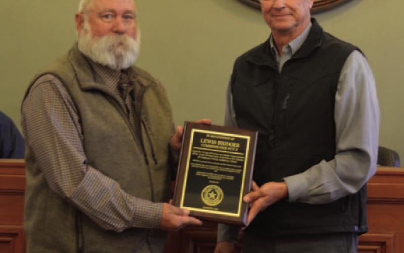 Precinct 3 Commissioner Lewis Bridges, left, accepts a plaque from County Judge Randy Hoyer to commemorate Bridges’ service to the county. His term as commissioner will conclude at the end of the month. ERICK MITCHELL | DISPATCH RECORD