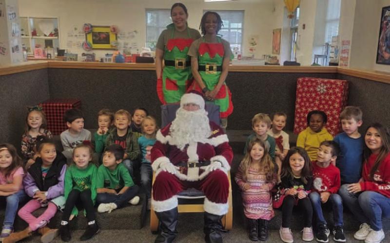 Mrs. Mickan’s kindergarten class poses for a photo with Santa Claus and two of his elves. COURTESY PHOTO