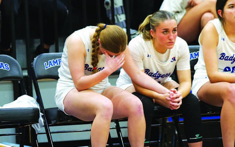HUNTER KING | DISPATCH RECORD Kari Kepler, left, and Payton Crawford hold hands as the Lady Badgers shoot late free throws.
