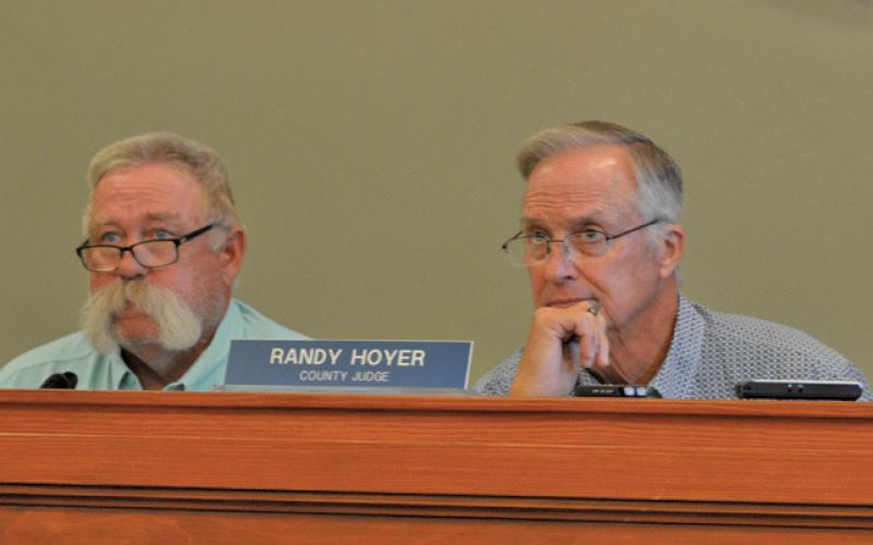 Precinct 3 Commissioner Lewis Bridges, at left, and County Judge Randy Hoyer listen to a presentation on the tax rate at Monday’s Commissioners Court meeting. erick mitchell | dispatch record