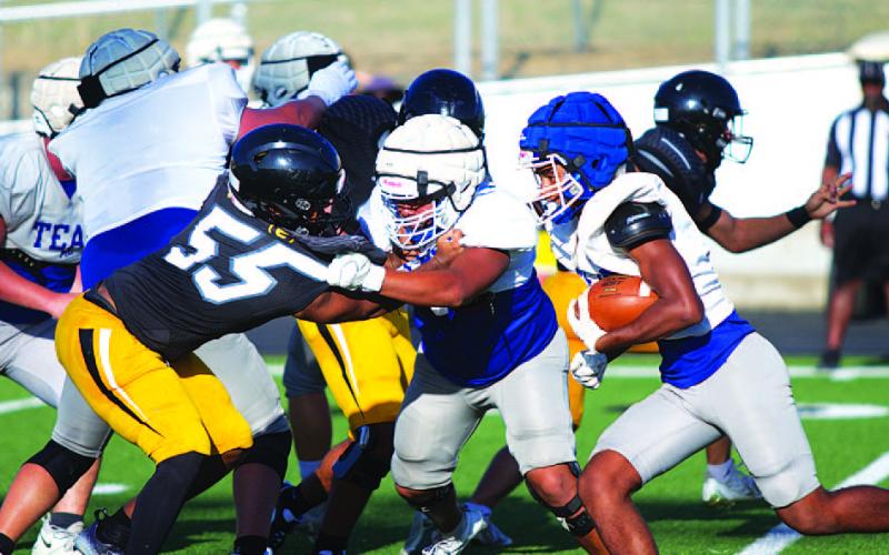 HUNTER KING | DISPATCH RECORD Kevin Castruita blocks as Wesley Stephens runs by the Hornet defender.