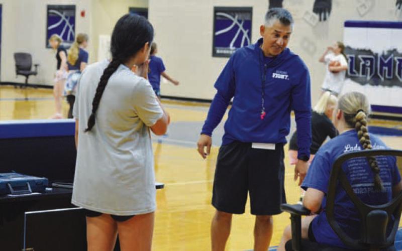 Marcus Chapa chats with a couple of his Lady Badgers at a camp last week. ERICK MITCHELL | DISPATCH RECORD